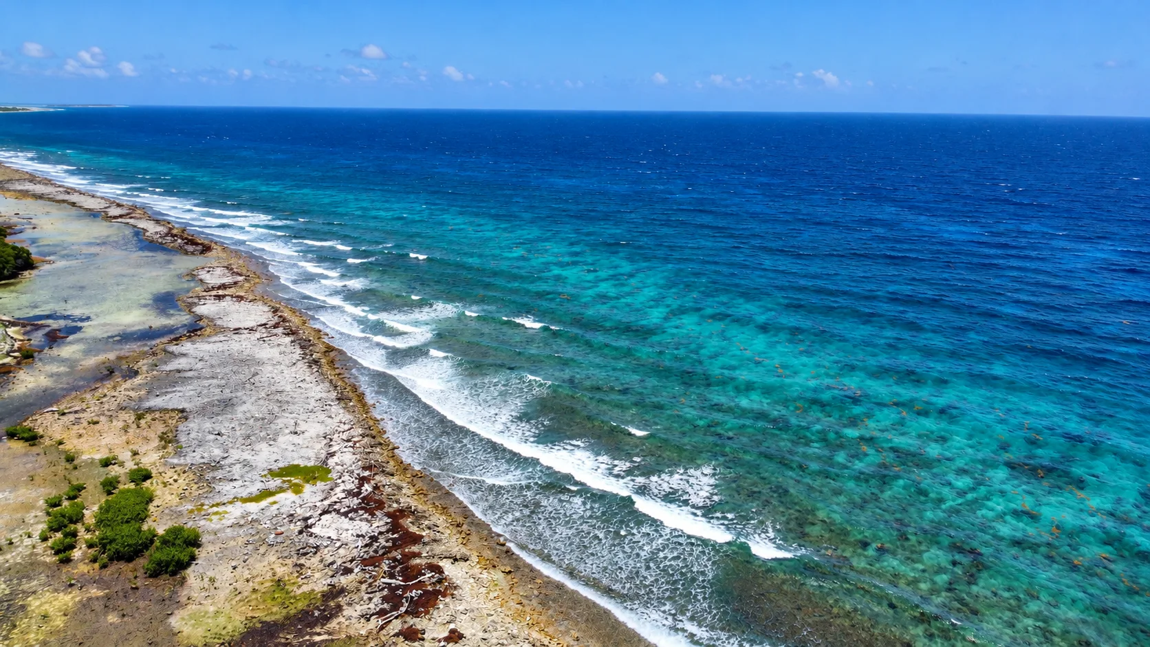 Aerial view of the turquoise reef along the island coastline