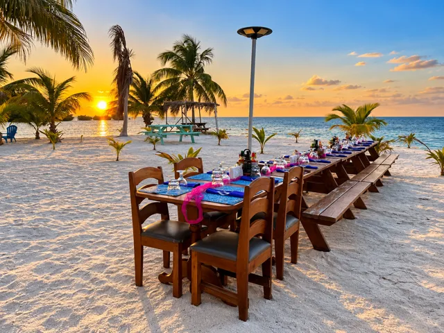 Long dining table on the beach at sunset